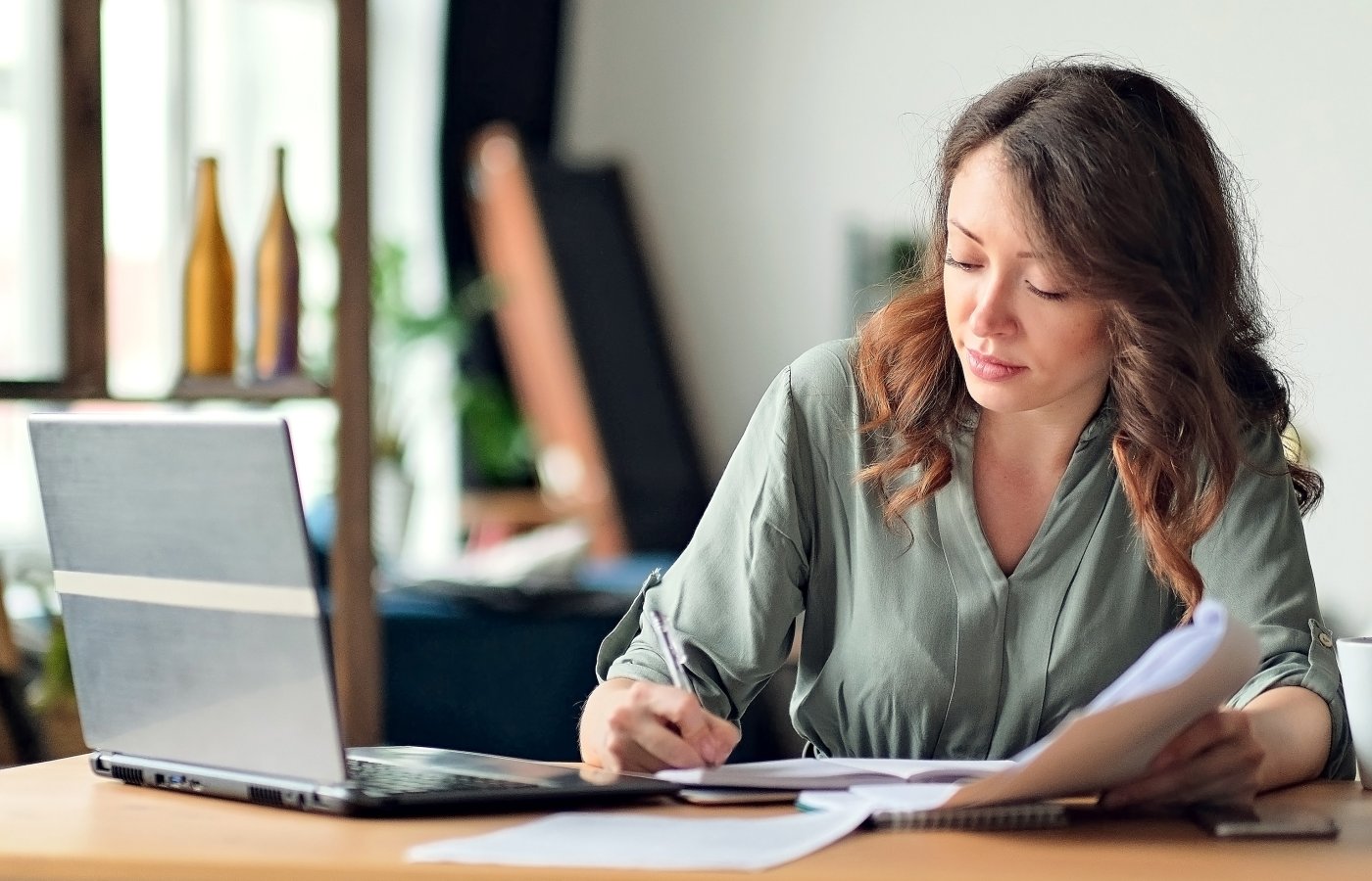 person working with paper and laptop