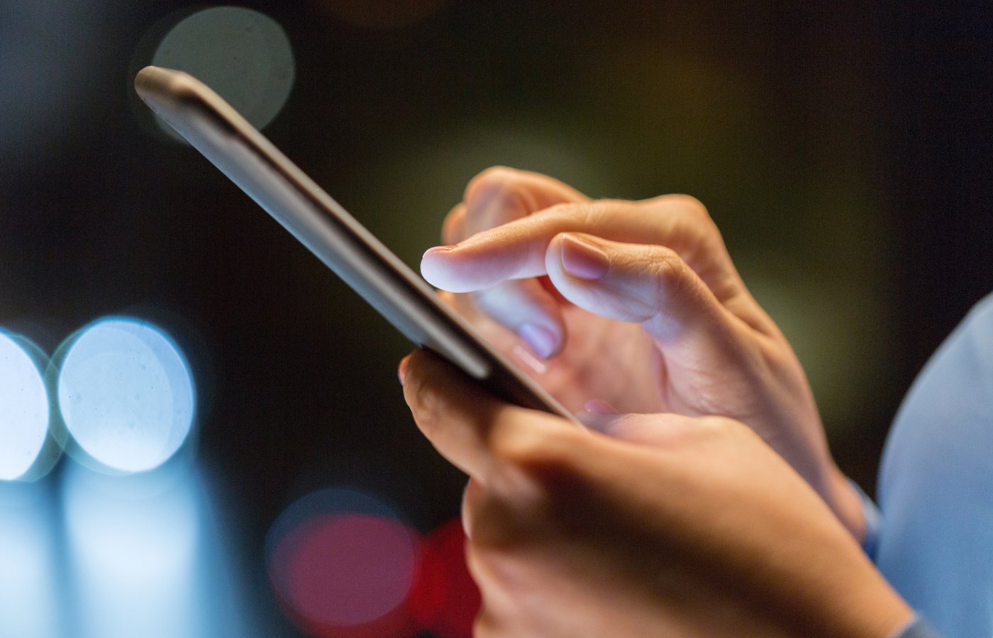 Close up of hands typing on a cell phone