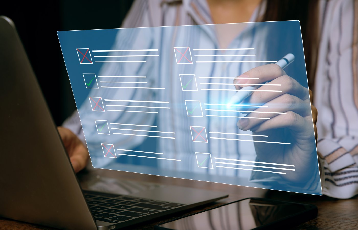 close up of a person selecting a check box next to text in a floating transparent screen above a computer. Portrays testing concept.
